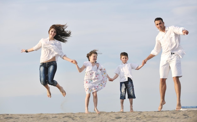 glückliche junge familie hat spaß und lebt einen gesunden lebensstil am strand