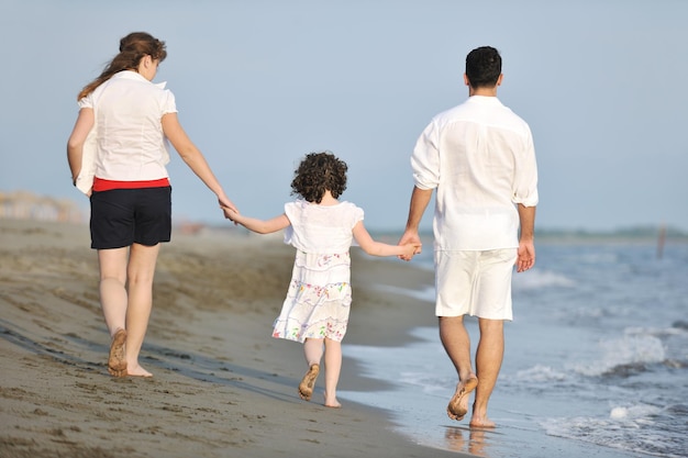 glückliche junge familie hat spaß und lebt einen gesunden lebensstil am strand