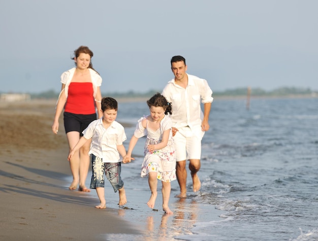 glückliche junge familie hat spaß und lebt einen gesunden lebensstil am strand