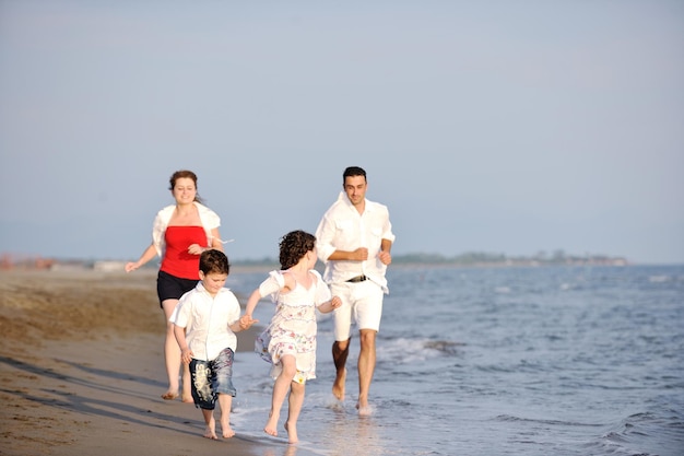 glückliche junge familie hat spaß und lebt einen gesunden lebensstil am strand