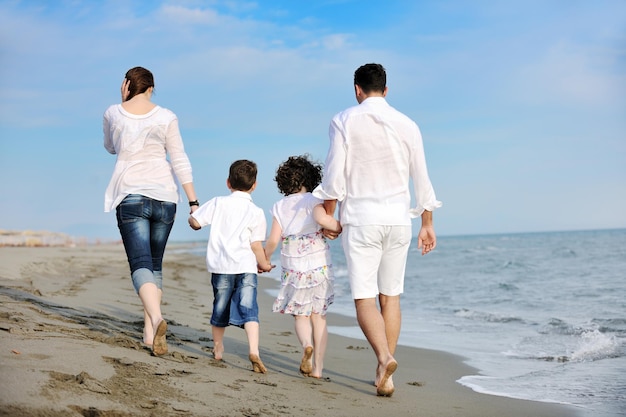 glückliche junge familie hat spaß und lebt einen gesunden lebensstil am strand