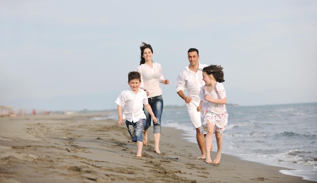 glückliche junge familie hat spaß und lebt einen gesunden lebensstil am strand