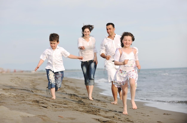 glückliche junge familie hat spaß und lebt einen gesunden lebensstil am strand