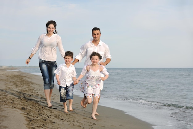 glückliche junge familie hat spaß und lebt einen gesunden lebensstil am strand