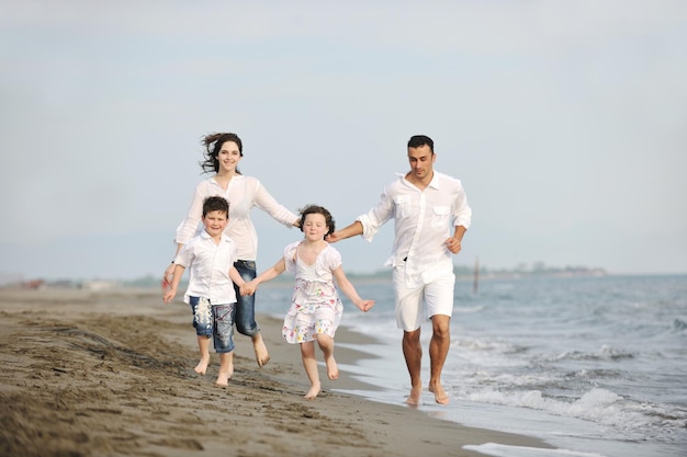 glückliche junge familie hat spaß und lebt einen gesunden lebensstil am strand