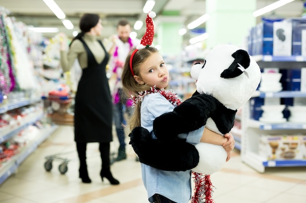 Glückliche junge Familie im Supermarkt wählt Geschenke