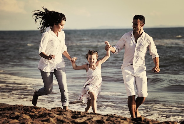 glückliche junge familie in weißer kleidung viel spaß im urlaub am schönen strand