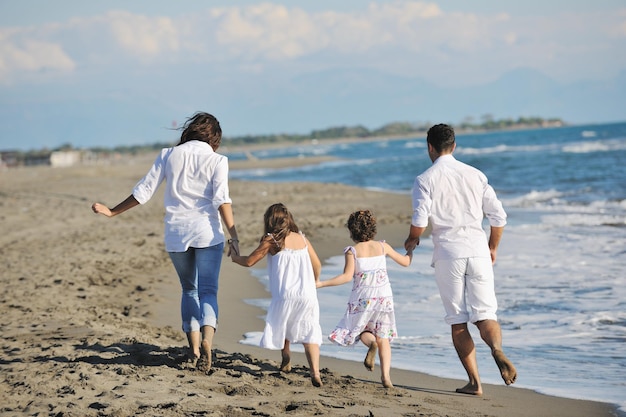 glückliche junge familie in weißer kleidung viel spaß im urlaub am schönen strand