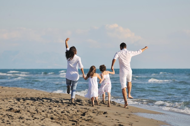 glückliche junge familie in weißer kleidung viel spaß im urlaub am schönen strand