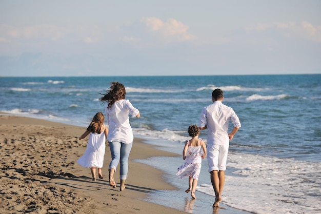 glückliche junge familie in weißer kleidung viel spaß im urlaub am schönen strand