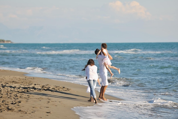 glückliche junge familie in weißer kleidung viel spaß im urlaub am schönen strand