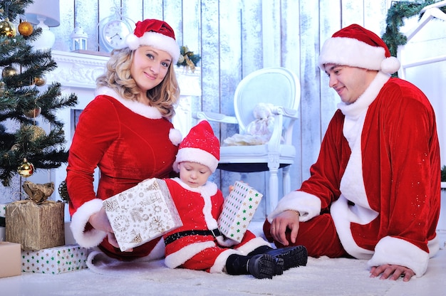 Foto glückliche junge familie mit einem kind mit weihnachtsgeschenk