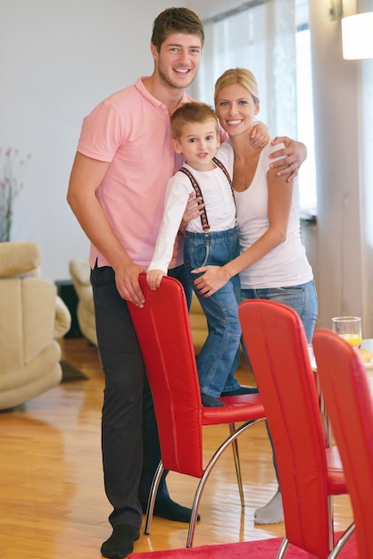 glückliche junge familie mit kindern im hellen modernen wohnzimmer haben spaß und sehen großen flachen lcd-fernseher aus