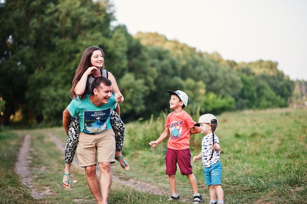 Glückliche junge Familie: Mutter, Vater, Sohn mit zwei Kindern über die Natur, die Spaß hat.