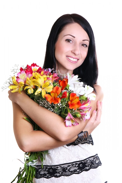 Glückliche junge Frau, die Blumen umarmt