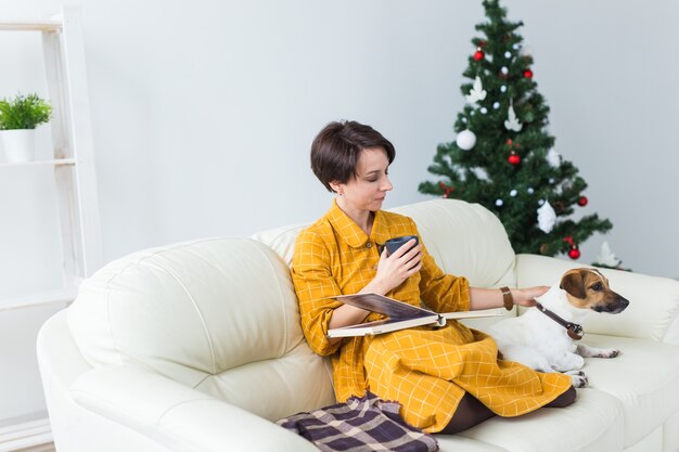 Glückliche junge Frau, die Buch zu Hause liest.