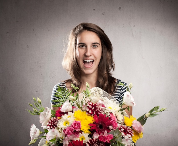 glückliche junge Frau, die einen Blumenstrauß hält