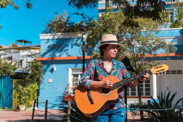 Glückliche junge Frau, die Gitarre spielt