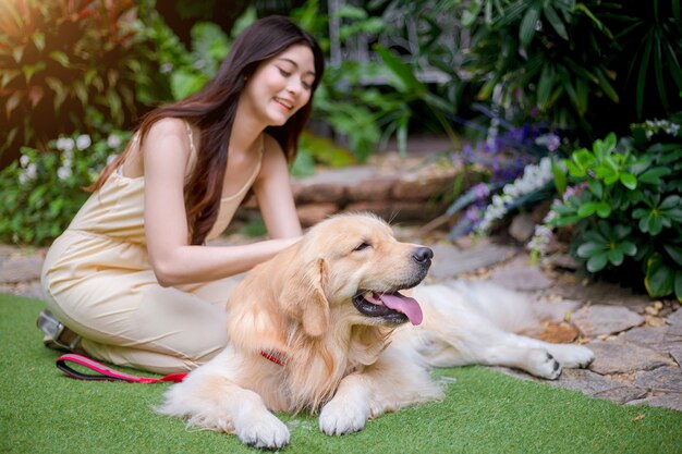 Glückliche junge Frau, die Hunde golden retriever hält.