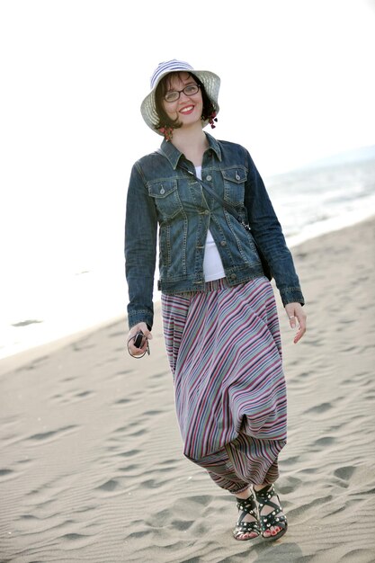 glückliche junge frau entspannen am schönen strand am frischen sommermorgen und genießen den ersten sonnenstrahl