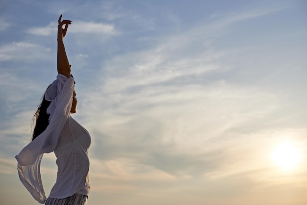 glückliche junge frau genießen sonnenuntergang beim tanzen und genießen musik über kopfhörer