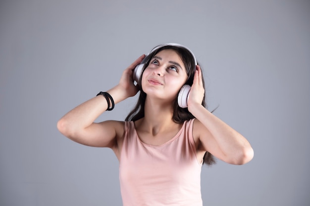 Glückliche junge Frau hört mit Kopfhörern zu