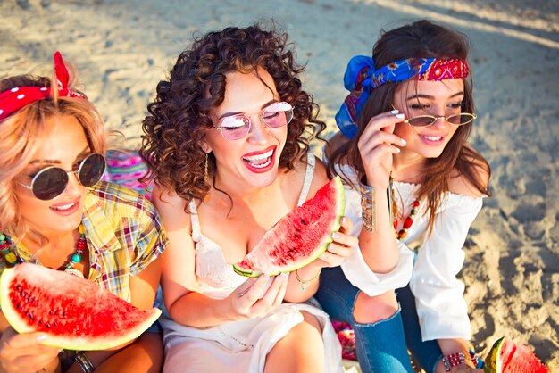 Foto glückliche junge frau mit sonnenbrille sitzt im freien