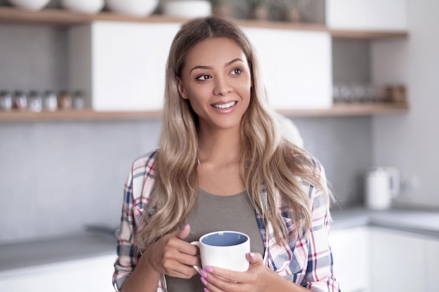 Glückliche junge Frau mit Tasse Kaffee