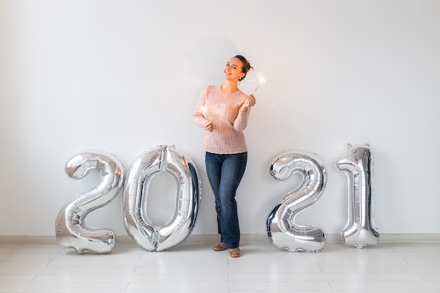 Glückliche junge Frau mit Wunderkerzen im Neujahrsurlaub