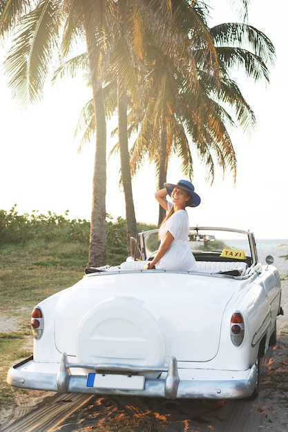 Glückliche junge Frau und Retro Cabrio Auto neben dem Strand bei Varadero Stadt