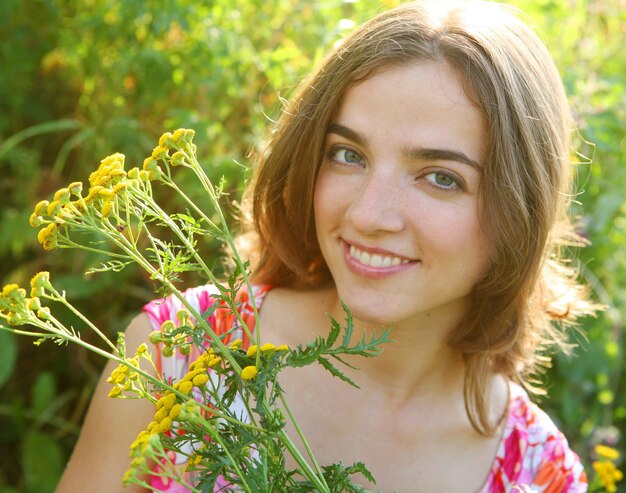 Foto glückliche junge frau und wilde blumen.