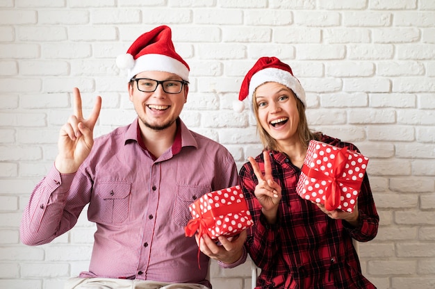 Glückliche junge Freunde, die Weihnachtsmütze tragen