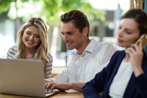 Foto glückliche junge freunde mit laptop