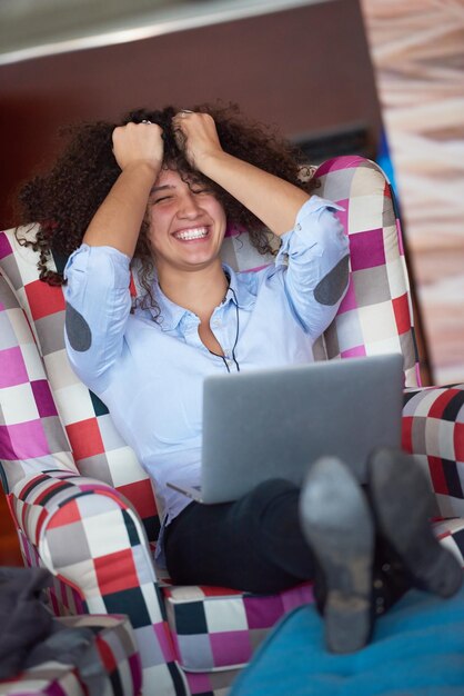 glückliche junge Geschäftsfrau mit lockiger Frisur im modernen Büro