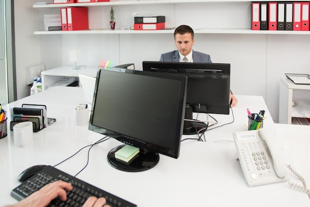 Glückliche junge Geschäftsleute arbeiten im modernen Büro am Computer