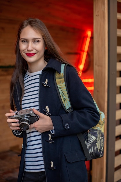 Glückliche junge Hipster-Frau hält Retro-Fotokamera. Spaß in der Stadt mit der Kamera, Reisefoto des Fotografen.