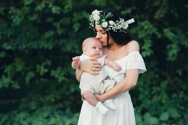 Glückliche junge kaukasische Mutter umarmt ihren neugeborenen Sohnjungen