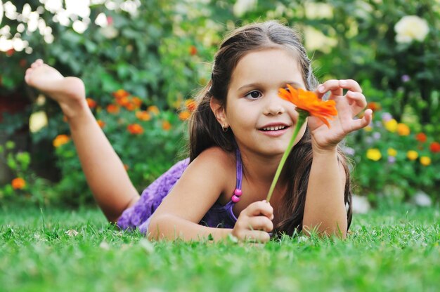 glückliche junge mädchen entspannen sich und haben spaß auf gras mit blume