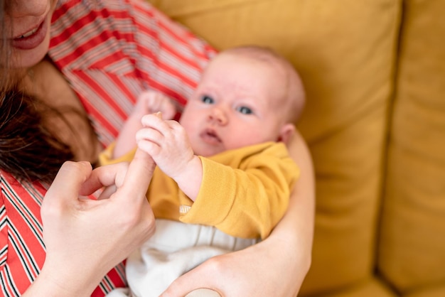 Glückliche junge Mutter hält sanft ein neugeborenes Baby