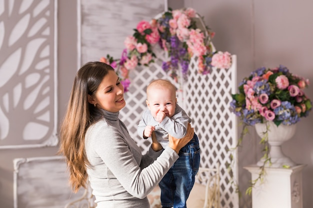 Glückliche junge Mutter und ihr süßes Baby.