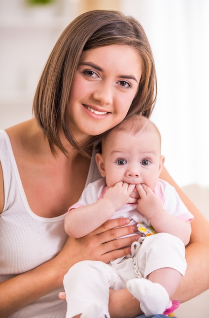 Glückliche junge Mutter und ihr süßes Baby.