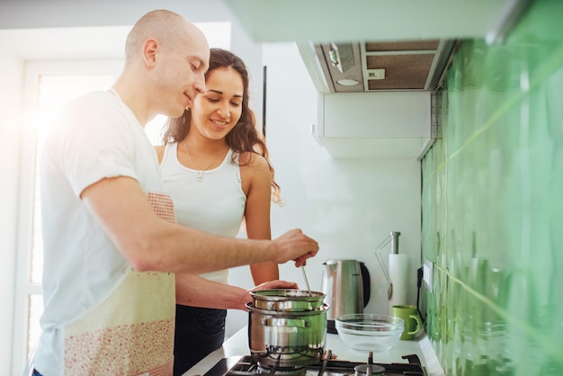 Glückliche junge Paare, die auf den Ofen sich vorbereiten