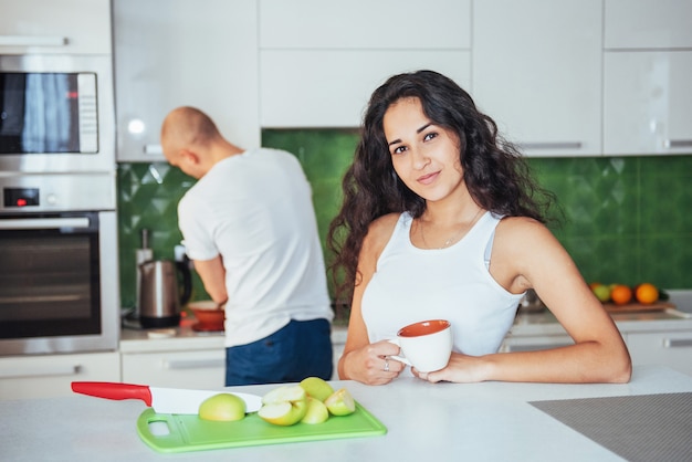 Glückliche junge Paare, die Kaffee in der Küche trinken