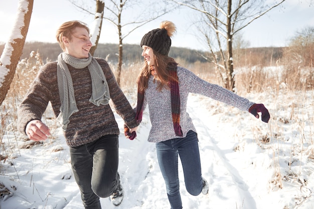 Glückliche junge Paare im Winterpark, der Spaß hat. Familie draußen.