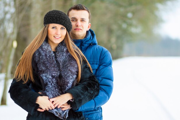 Glückliche junge Paare im Winterpark, der Spaß hat