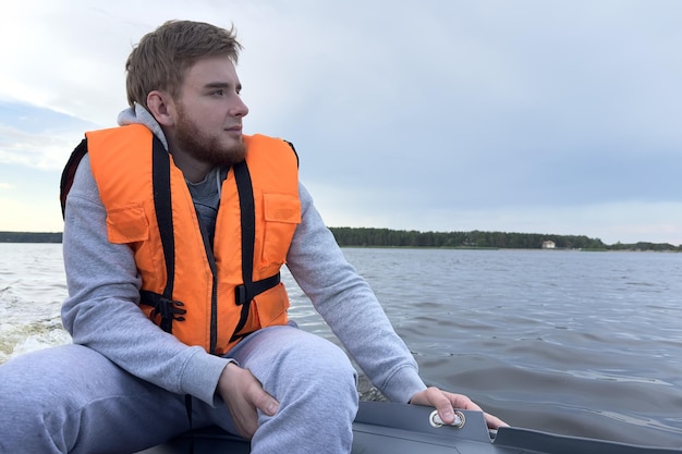 Glückliche junge Reisende in Schwimmweste schwimmt im Boot auf dem plätschernden Fluss