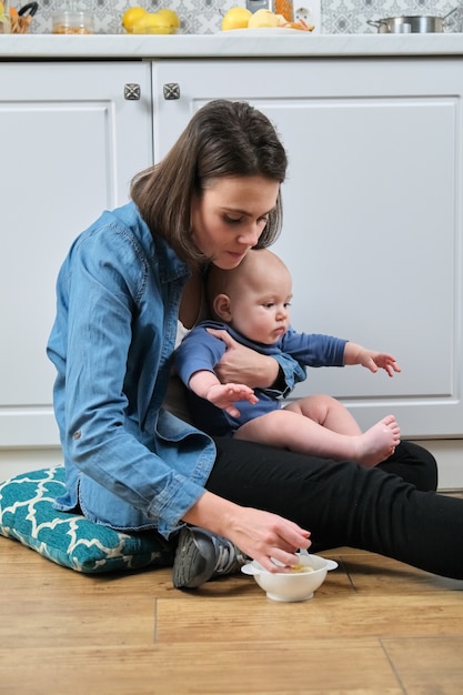 Glückliche junge schöne Mutter, die mit Kleinkindsohn spielt