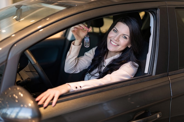 Glückliche Käuferin überprüft ihr neues Fahrzeug im Autohaus