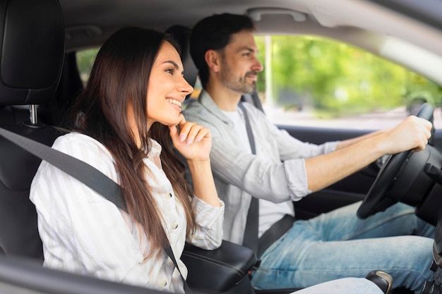 Glückliche kaukasische Männer und Frauen, die mit dem Auto in den Urlaub fahren