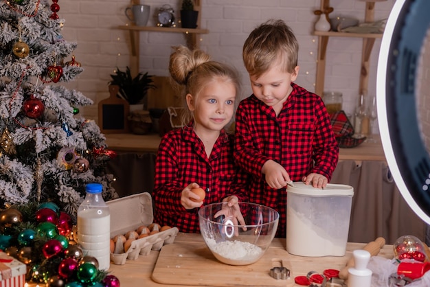 Glückliche Kinder backen zu Hause in der Küche Weihnachtsplätzchen